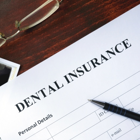 Dental insurance form on dark wood table
