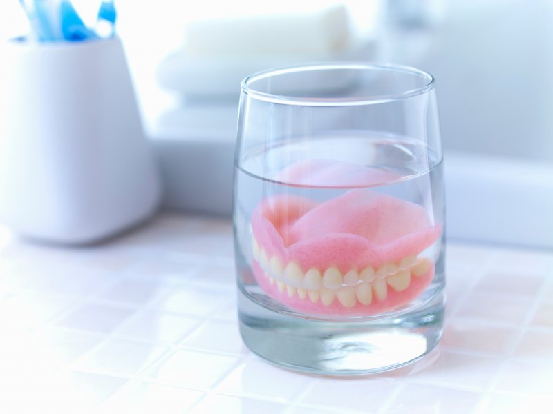a pair of dentures soaking on the sink